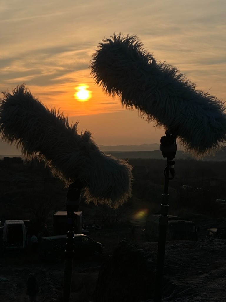 44 unit — twin boom deadcats silhouetted against a sunset over the hills