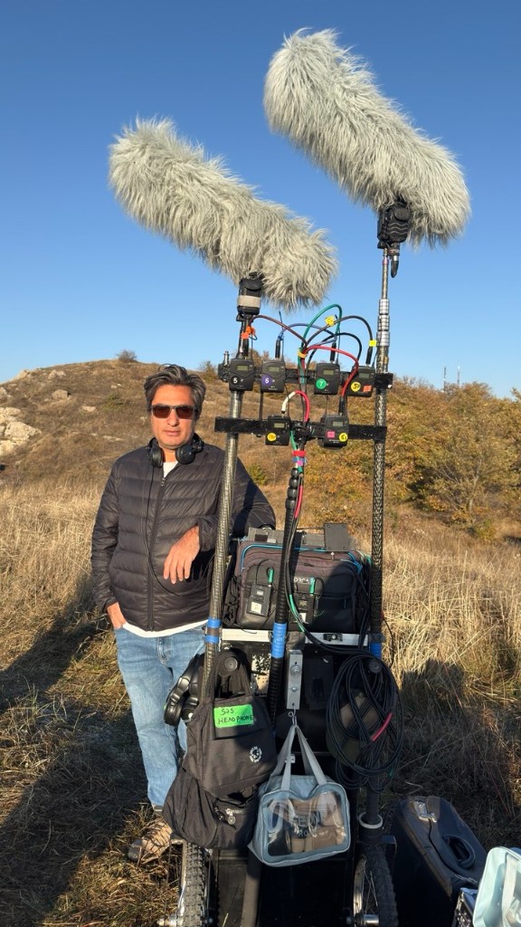44 unit — sound recordist with twin-boom cart on dry hills under clear sky