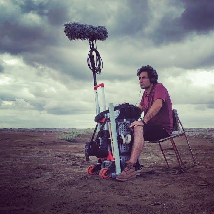 Sound recordist at the cart with boom upright under heavy cloud cover