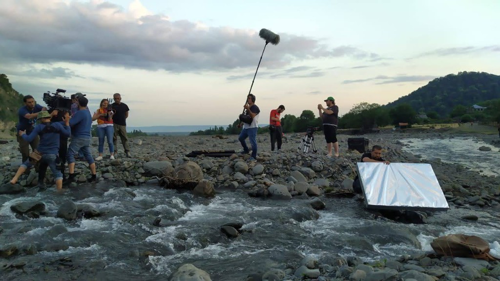 Maryam unit on a rocky riverbed — boom, camera, and reflector in frame