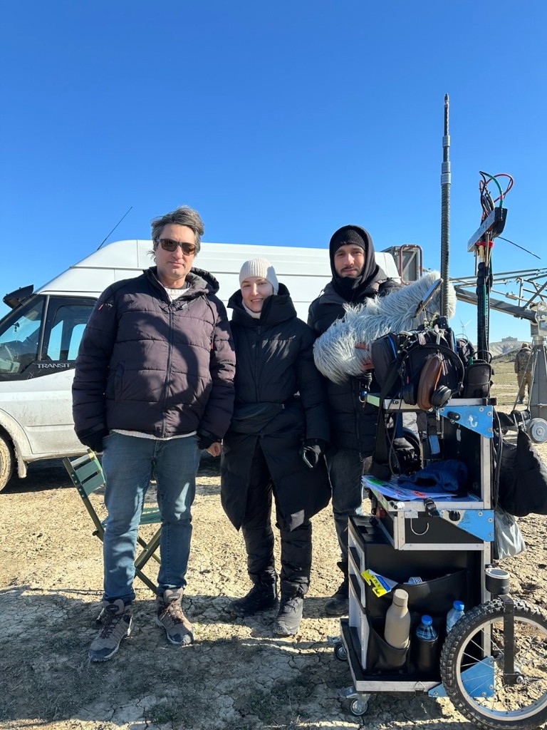 Mənə Bənzər Adam unit — sound cart and crew beside the production van on cracked ground