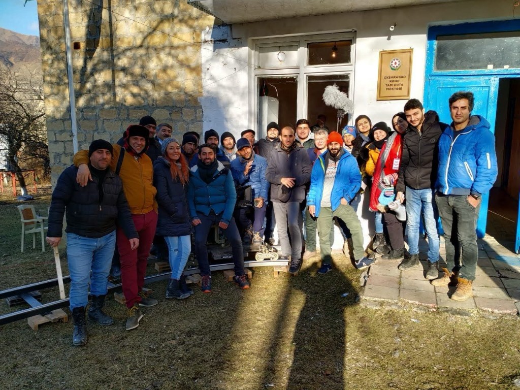Oxşarabad crew group photo in front of the village school plaque