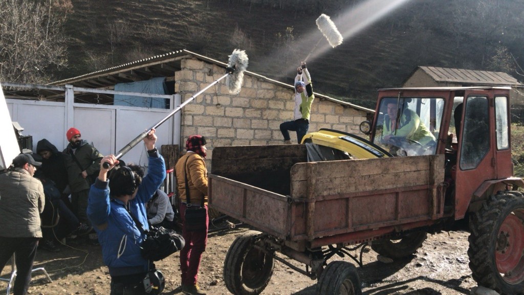 Twin boom operators covering a red tractor scene on the Oxşarabad village unit