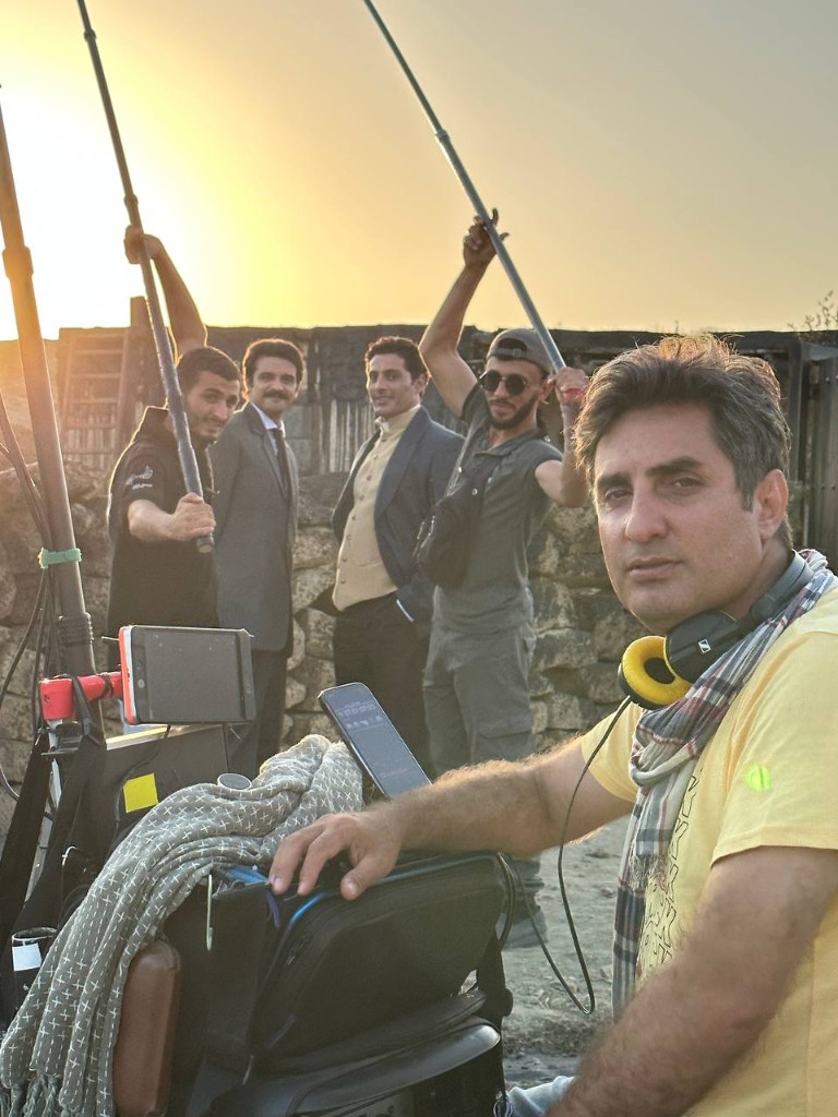 Sound mixer at golden hour with boom team and period cast