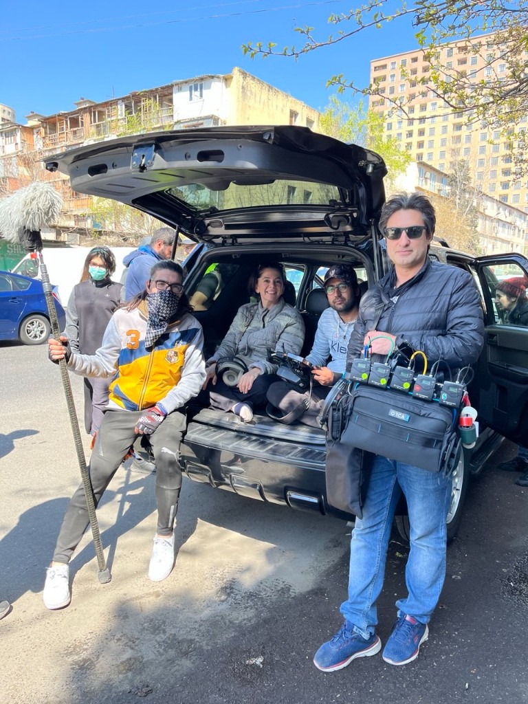 Sound mixer with Orca bag and boom operator by an SUV